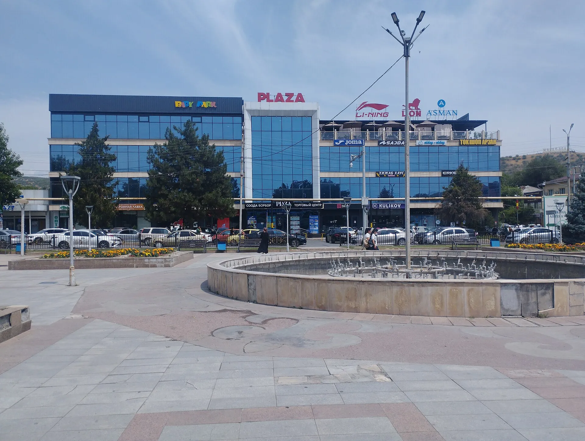 Площадь с фонтаном и городской застройкой Манаса