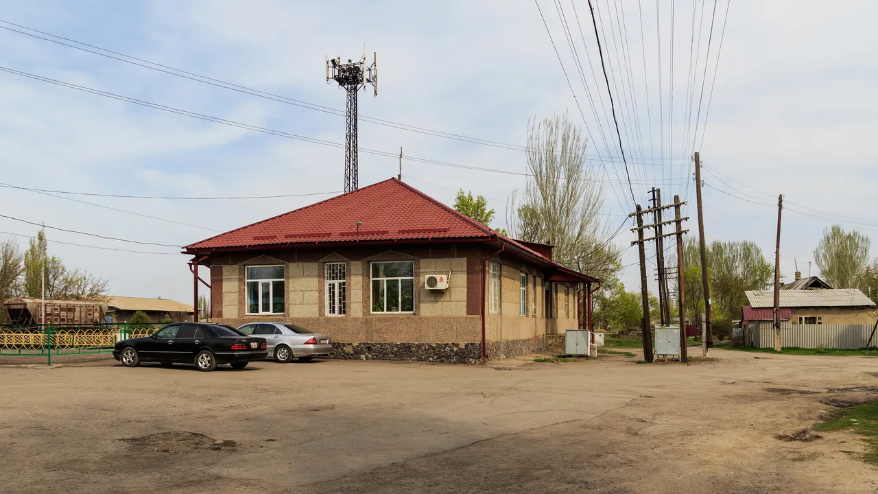 Небольшое здание железнодорожной станции Кант рядом с путями и городской улицей