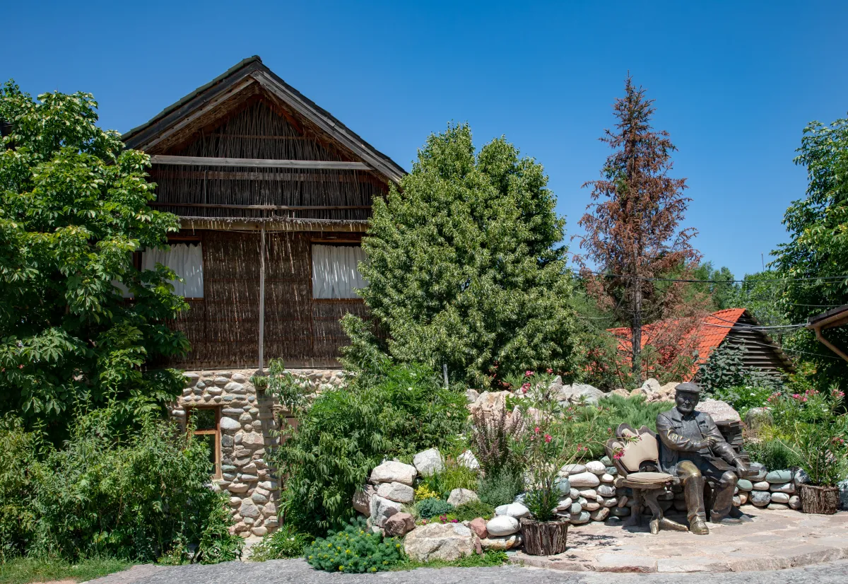 Jardin, bâtiment de pierre et sculpture sur le domaine de Supara