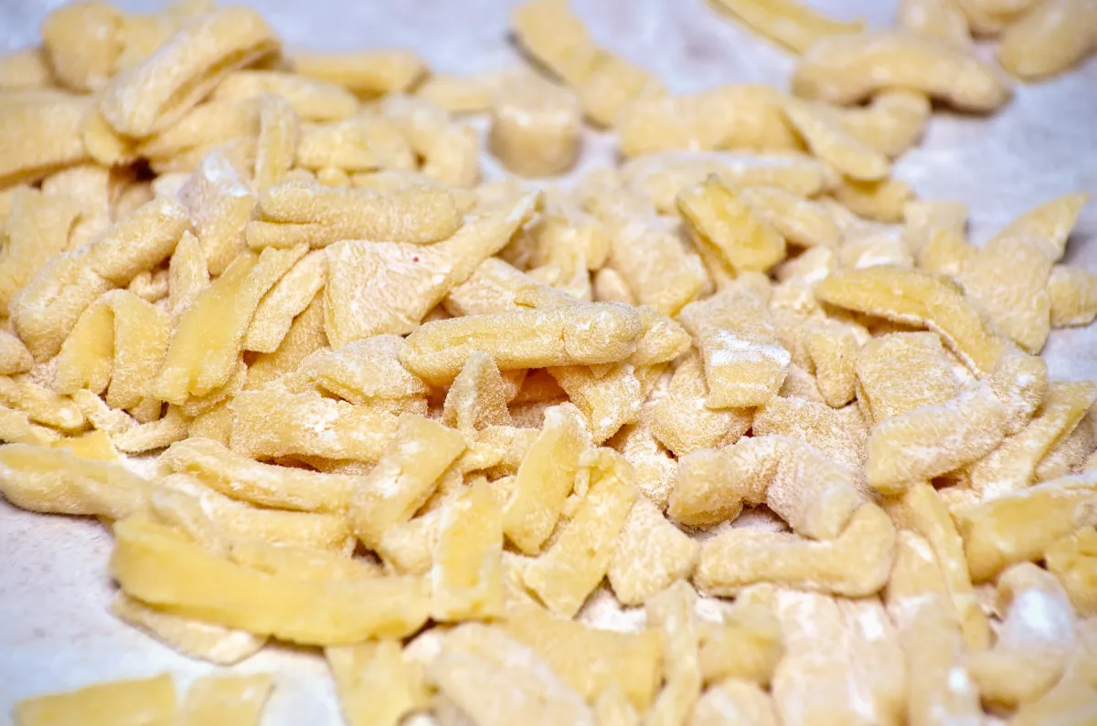 Courtes lanières de pâte crue découpées avant la friture