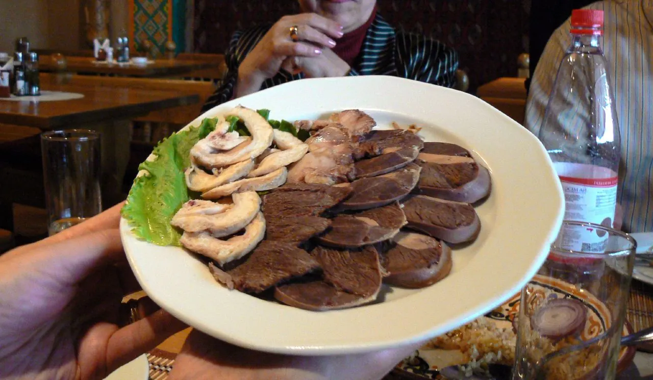 Assiette de trois préparations froides de viande de cheval, avec des tranches de kazy à droite