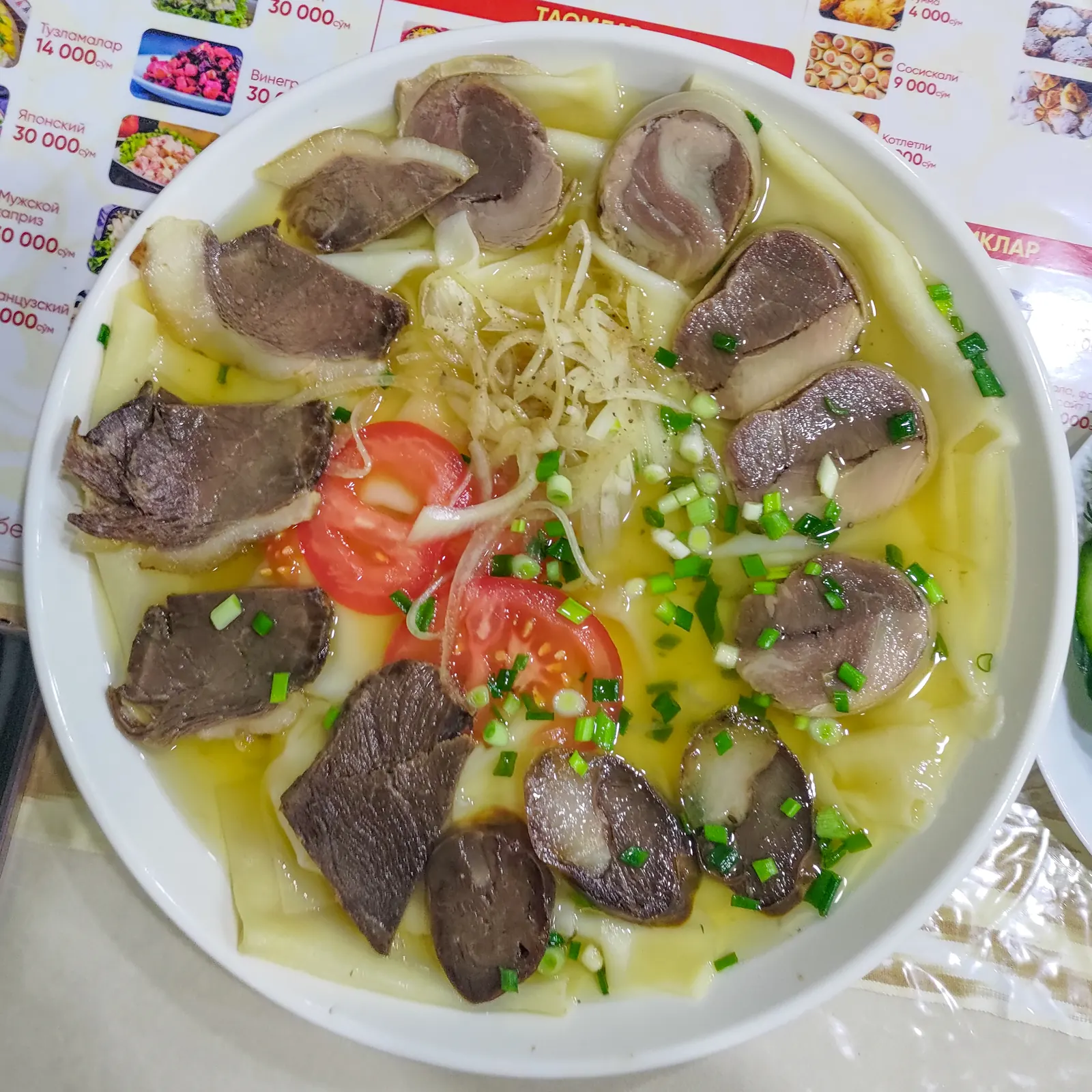 Beshbarmak aux nouilles, à la viande et aux rondelles de kazy servi à Tachkent