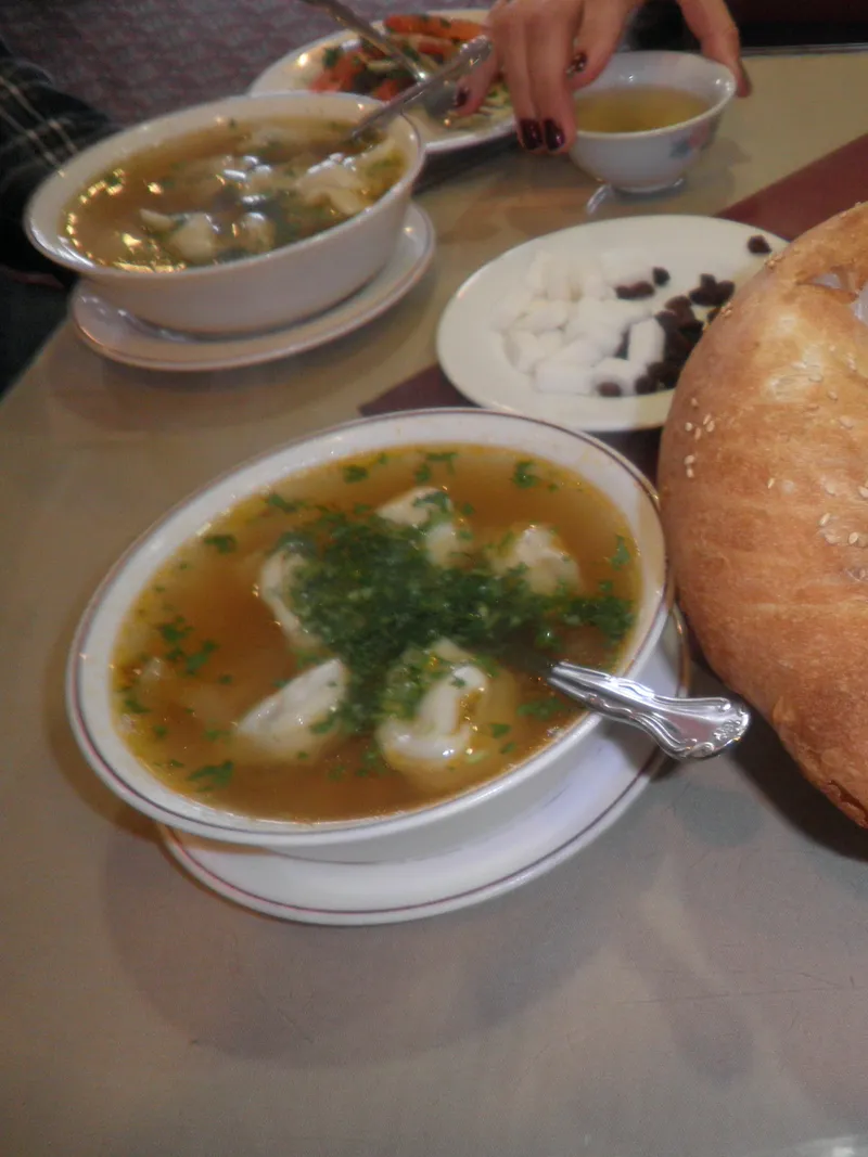Masada Orta Asya usulü tuşpara çorbası dolu kâseler ve büyük yuvarlak ekmek