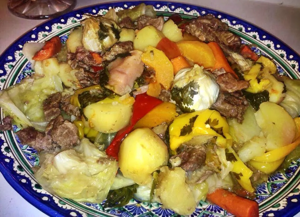 Büyük desenli tabakta et, patates, havuç, biber ve lahana parçaları