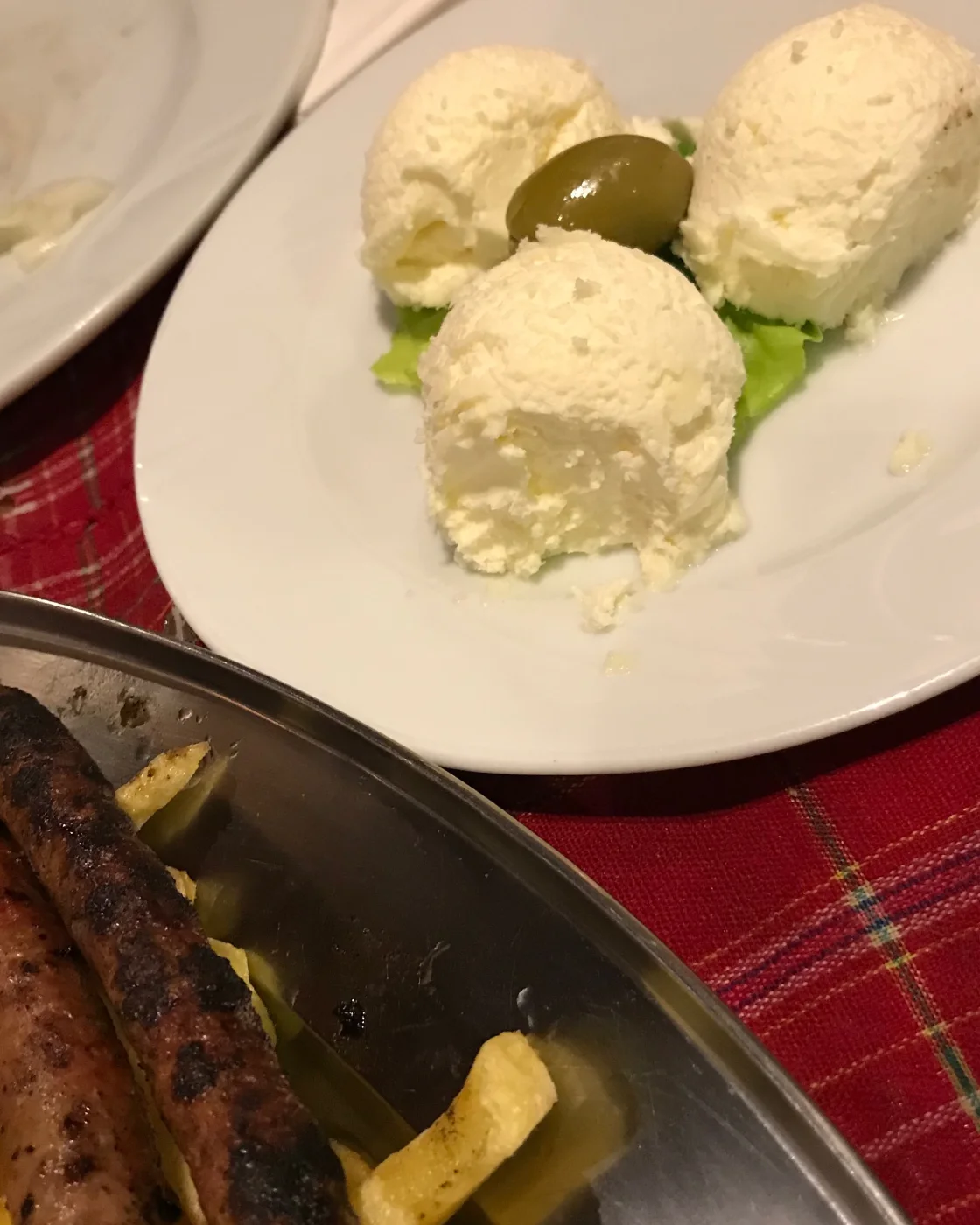 Плотный каймак подан округлыми порциями на тарелке в Черногории