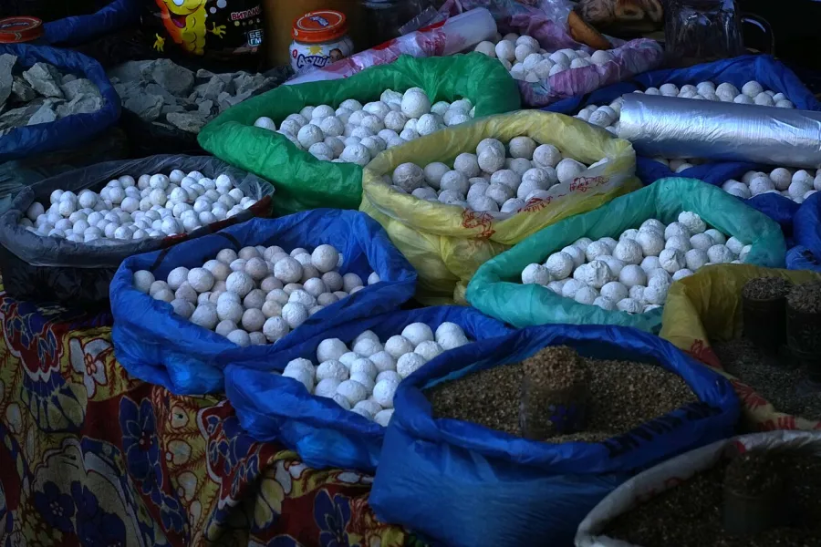 Sacs remplis de petites boules blanches de kurut sur un marché d’Och