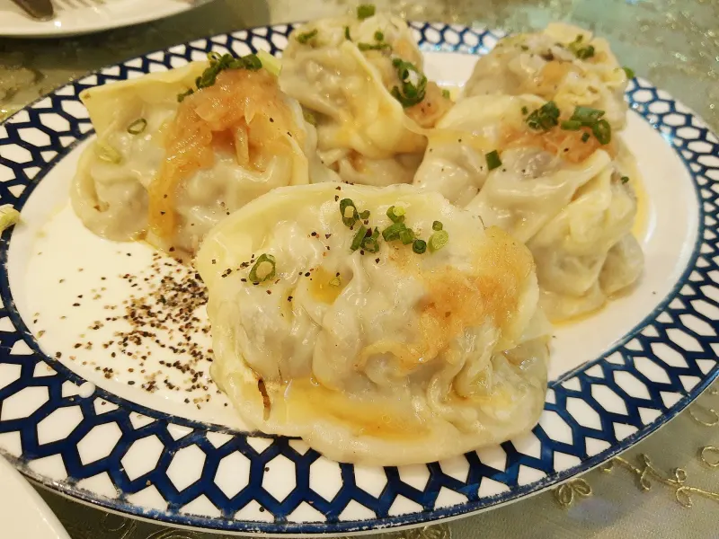 De grands manty cuits à la vapeur sont disposés sur une assiette