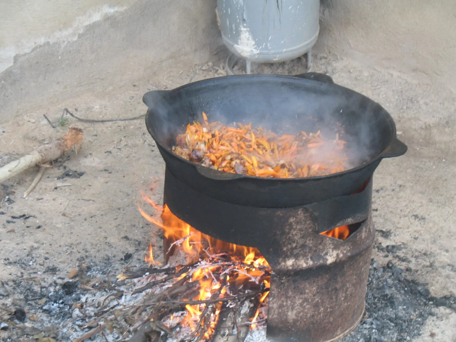 Мясо, лук и морковь обжариваются в казане на огне