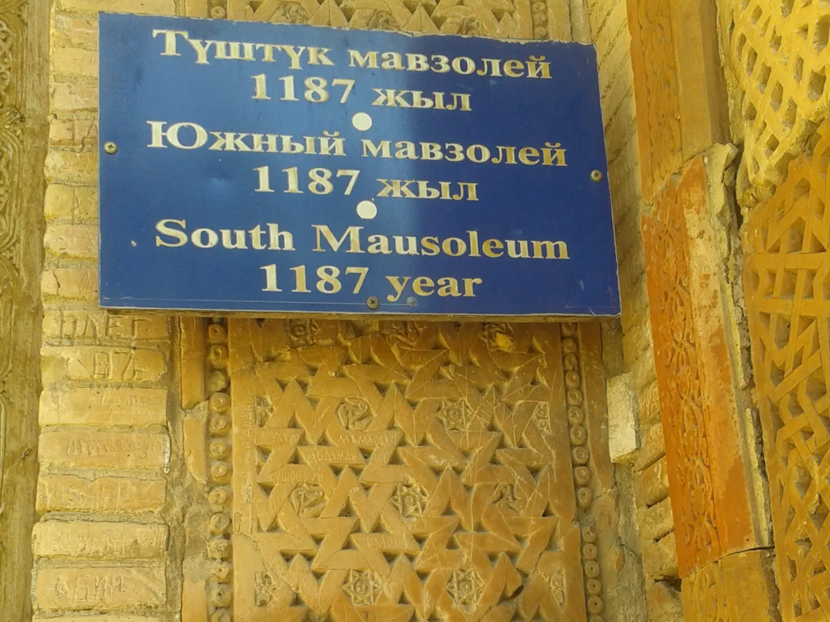 Panneau du mausolée sud à Uzgen rédigé en kirghize, en russe et en anglais