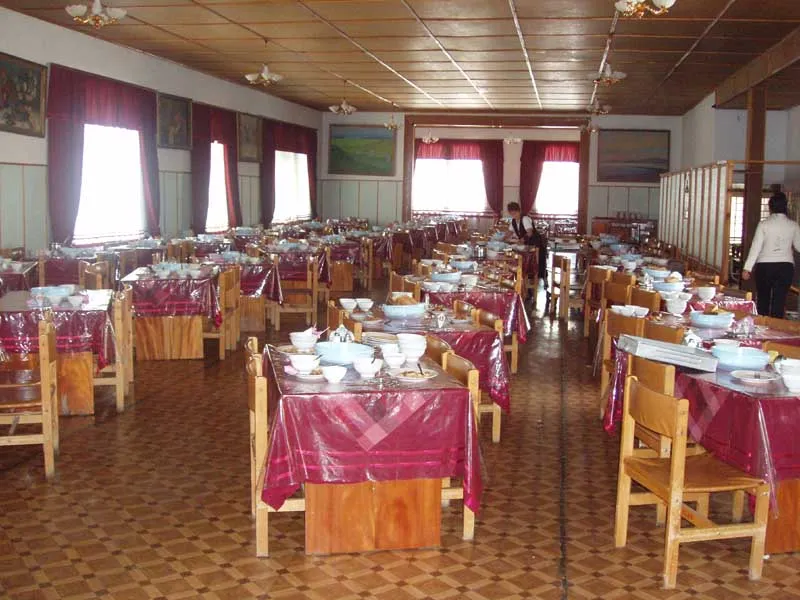Salle de la cantine de la station d’Issyk-Ata avec les tables dressées