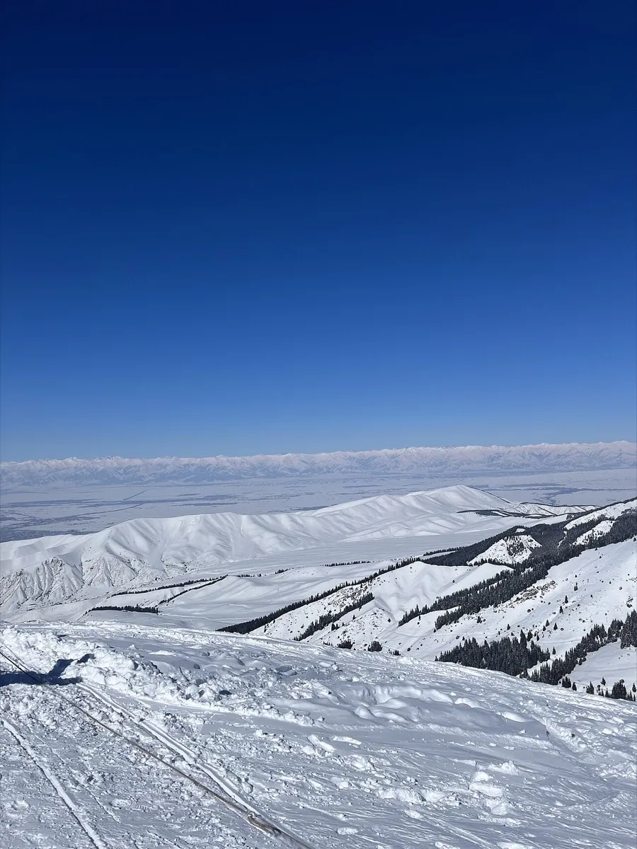 Pente enneigée de la station de Karakol avec une vue en direction d’Issyk-Koul