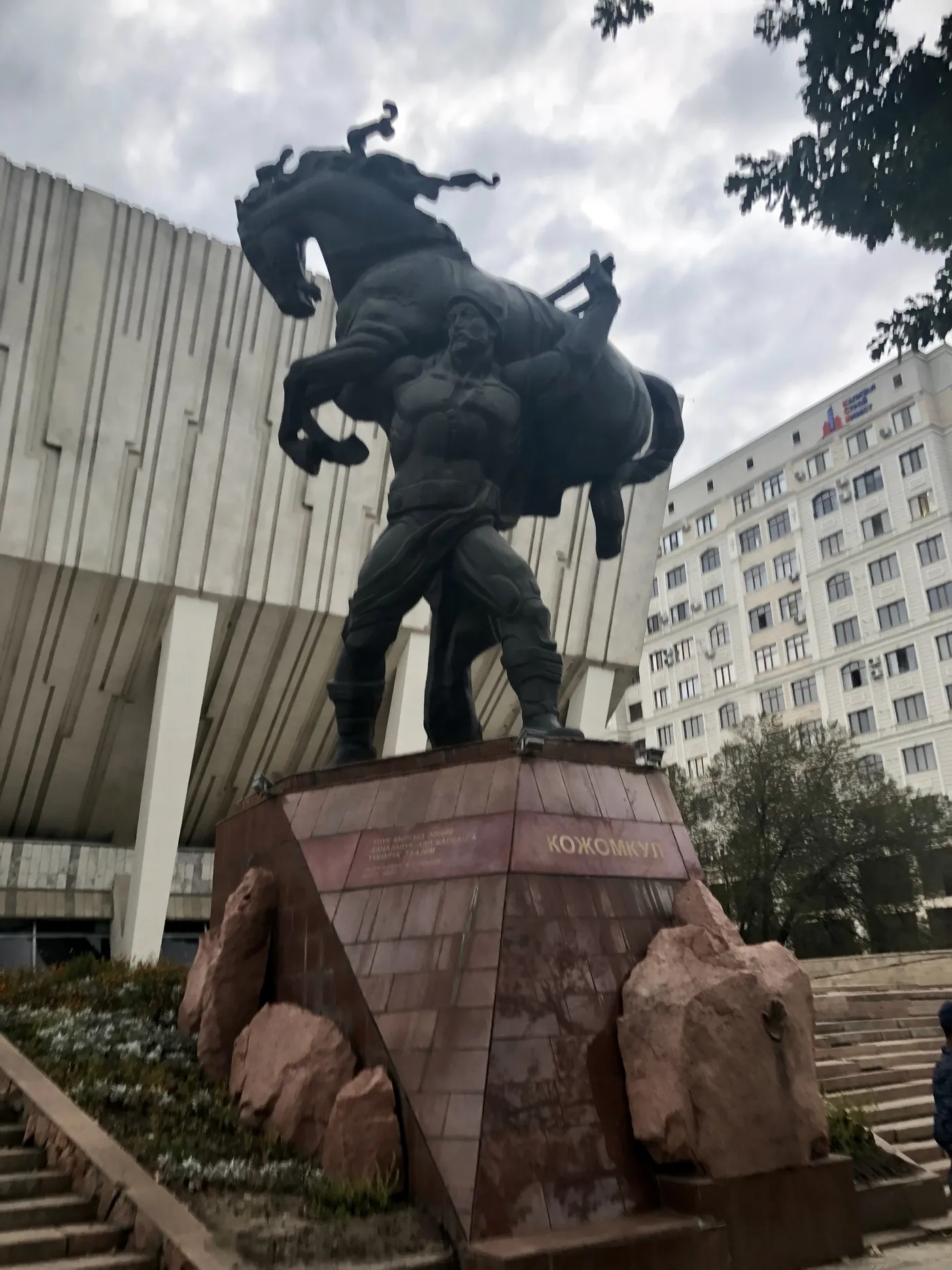 Памятник Кожомкулу с конём на плечах перед Дворцом спорта в Бишкеке
